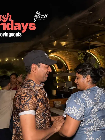Two dancers sharing a smile and a moment at our open-air social. The beautiful setting at Flow, with its unique architecture and lighting, creates the perfect backdrop for a night of Latin dancing.