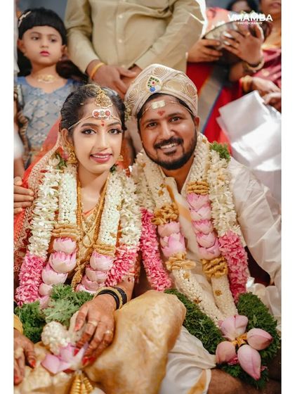 A classic portrait of the bride and groom, seated together during their wedding ceremony, looking at the camera. A beautiful memory for their families.