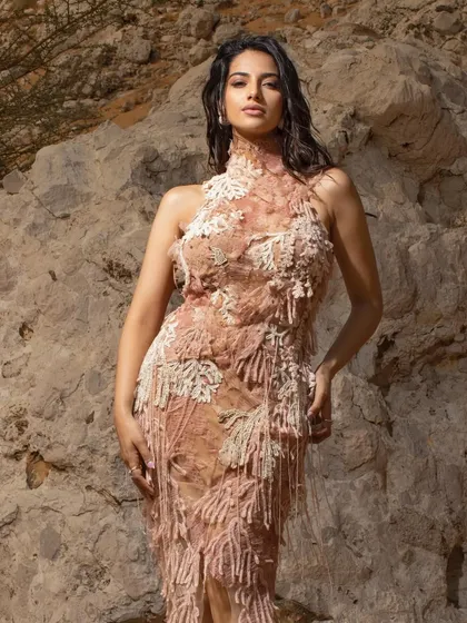 For this desert editorial, I chose a highly textured, fringed gown in a nude palette that blends with the rocky surroundings. The wet hair look adds a raw, elemental feel.