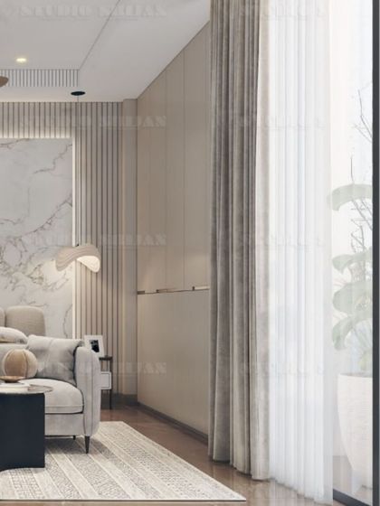 A bedroom in DLF Gurgaon with a serene, hotel-like feel, featuring a marble accent wall, fluted paneling, and soft, neutral-colored furnishings.