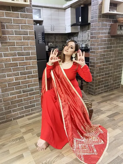 Celebrating Karwachauth in a red suit, accessorized with beautiful traditional chandbali earrings.