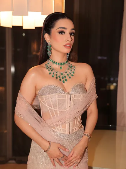 A dreamy reception look in a Tarun Tahiliani corset gown. The makeup is soft and ethereal, with a focus on glowing skin and sparkling emeralds.