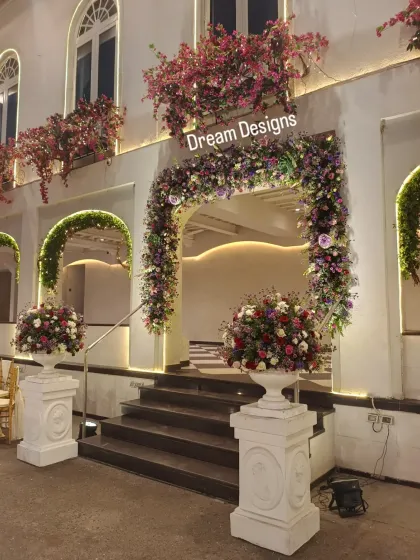 Another angle of the floral-adorned entrance, showing how the lighting highlights the textures of the flowers and the classic design of the building. Every detail is considered to create a cohesive and beautiful scene.