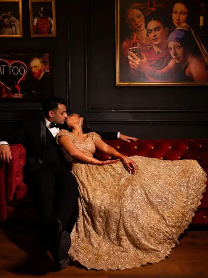An intimate kiss on a vintage red sofa. This cocktail night portrait has a classic, romantic, and slightly moody feel.