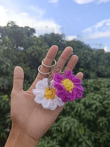 A pair of flower keychains in white and purple, perfect for adding a floral touch to any set of keys or bag.