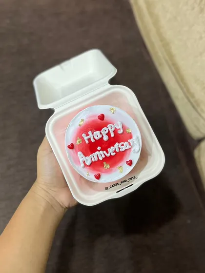 A cute and trendy bento box anniversary cake with red frosting and gold leaf.