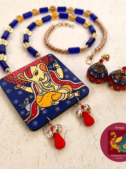 This vibrant necklace set features Lord Ganesha, the remover of obstacles. I used a deep blue background to make the colours pop. The set is completed with hand-painted wooden jhumkas and glass beads, perfect for auspicious beginnings.
