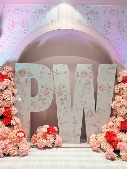 A photo of the 'PW' floral letter installation, with towers of pink and red carnations.