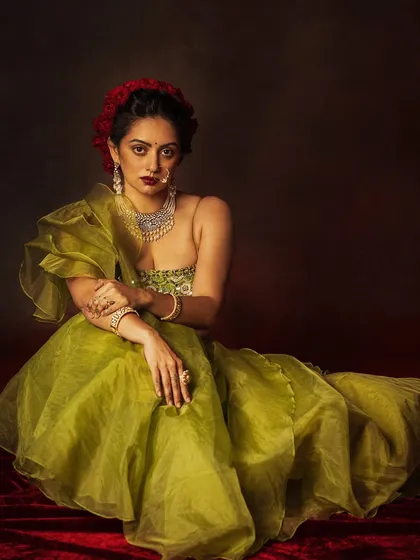 A seated portrait that showcases the voluminous and airy feel of the organza lehenga skirt.