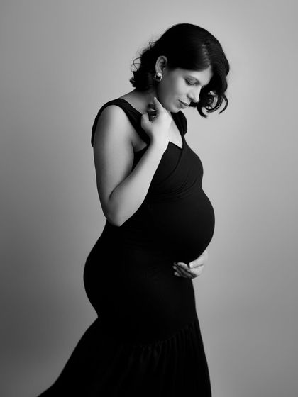 The grace of motherhood captured in a classic black and white profile. The elegant lines of her dress and the gentle curve of her bump create a truly timeless image.