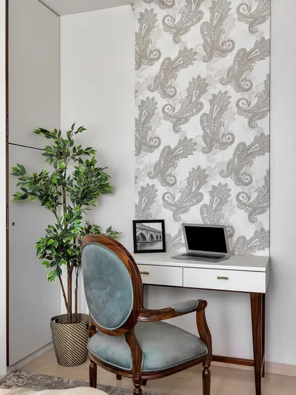 Your 9-to-5 just scored some serious style points. This chic home office corner features a classic wooden desk and a velvet-upholstered chair, set against a beautiful paisley wallpaper for an artistic touch.