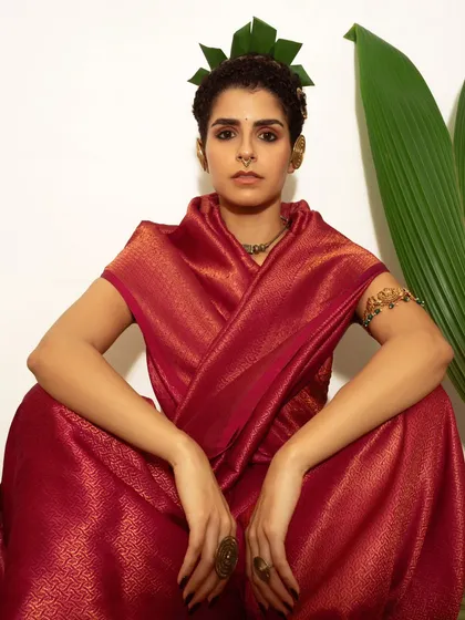 A direct, centered portrait that captures a moment of calm confidence. The symmetry of the pose and the rich color of the saree make this a powerful and engaging image.