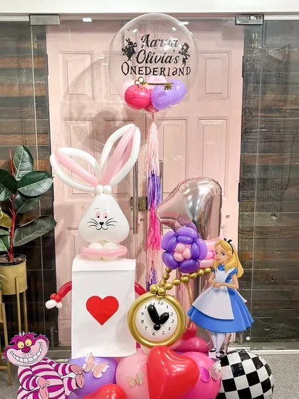 A full view of the Alice in "Onederland" setup, complete with a personalized bubble balloon. Every element is carefully placed to tell a story and create a picture-perfect moment for a special celebration.