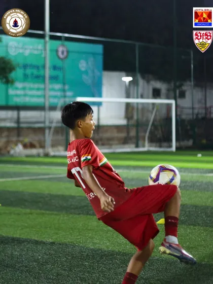 A young player executes a perfect volley. We focus on technical excellence and skill development under the floodlights.