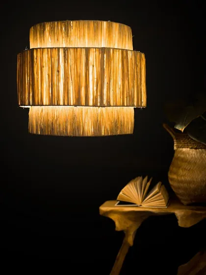 I love experimenting with different textures, and this tiered lampshade is crafted from raw natural fibers to create a rich, layered effect. When lit, it radiates a gentle, warm light that highlights the material's organic quality.