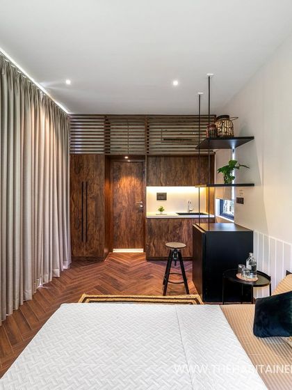 Another angle of the 240 sq. ft. pod, highlighting the herringbone wood flooring and full-length curtains that add a touch of luxury.