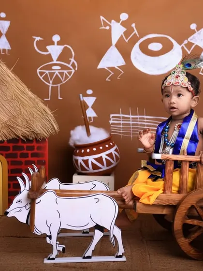 A candid moment captured during the Janmashtami session. The child's natural pose and expression add a layer of authenticity to this festive photoshoot.