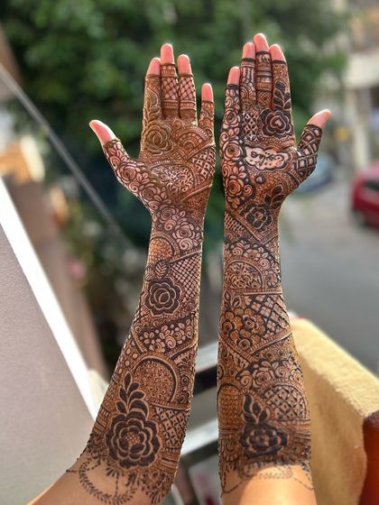 A beautiful shot of a full bridal mehendi, held up against a lovely green background. The details are crisp and clear.