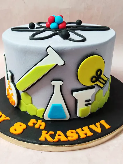 A side view of our chemistry cake, showing the variety of lab equipment and molecular structures.