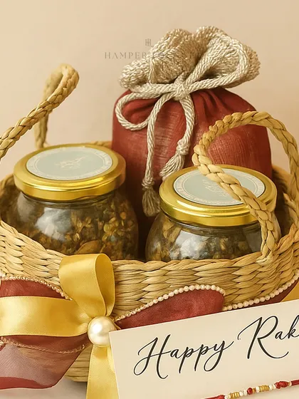 A close-up of the eco-chic jute basket hamper for Rakhi. The natural texture of the basket, paired with a rich red potli and a gold ribbon, creates a rustic yet elegant look.
