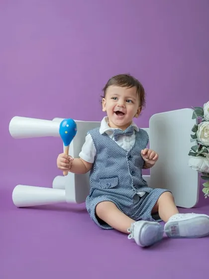 A burst of laughter from this well-dressed toddler. I love capturing these candid moments of pure joy during my classic portrait sessions.