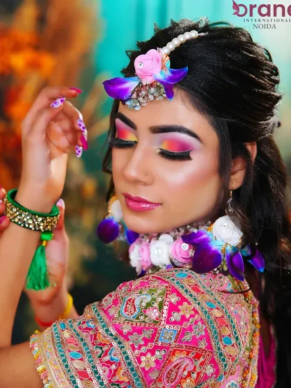 This pose highlights the intricate floral jewelry and the perfectly matching vibrant makeup.