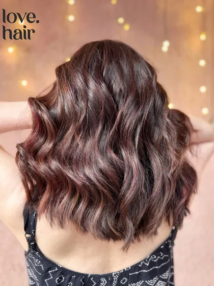Mellow mahogany. A rich, reddish-brown balayage that adds warmth and sophistication to this wavy lob.