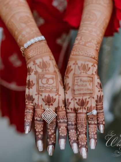 A close-up of the bride's intricate Mehendi design, which tells a story. We love incorporating personal elements like the wedding date and special phrases into the henna art.