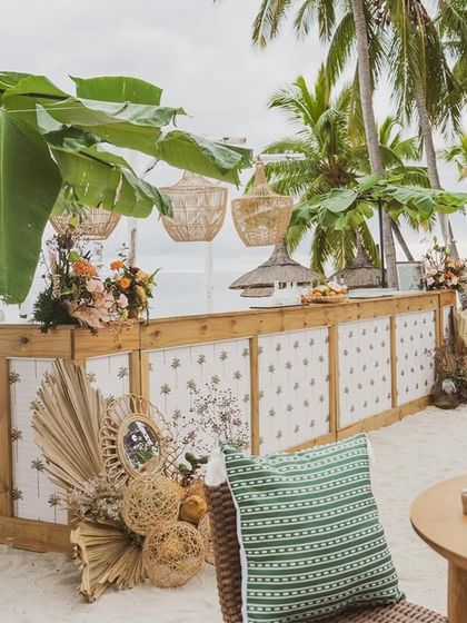 The beach bar is shaded by large banana leaves, integrating local flora directly into the design.