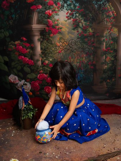 A playful moment as our little Radha reaches for her makhan. These candid shots add so much personality to our themed sessions.