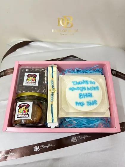 A top-down view of the hamper, showing the "Thanks for always being by my side BHAI" message on the bento cake.