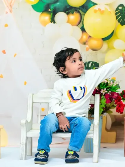This toddler playfully reaches for the "TWO" blocks during his second birthday photoshoot. I encourage natural interactions with the props to capture authentic and lively moments.