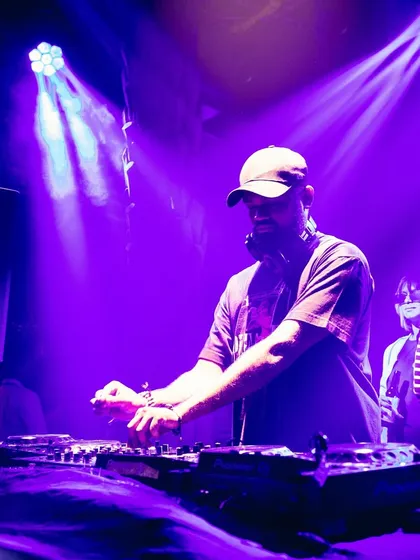 A purple-lit shot of me at the decks, showing the impressive lighting rig at a club event.
