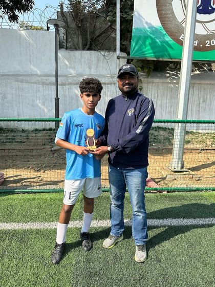 Recognizing excellence on the field. One of our U-17 players receives the Player of the Match award from our coach.