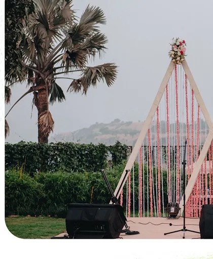 The stage setup for an outdoor event, featuring modern geometric frames and floral details against a beautiful natural backdrop.