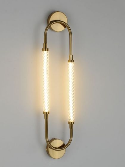 A product shot of our elegant U-shaped wall sconce with textured light tubes. The brass finish adds a touch of warmth and luxury.