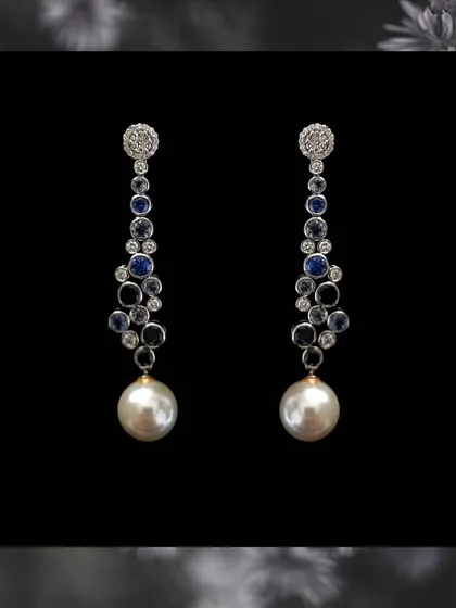 A classic combination of blue sapphires, diamonds, and a large south sea pearl drop. These long earrings are the epitome of elegance and are perfect for an evening event.