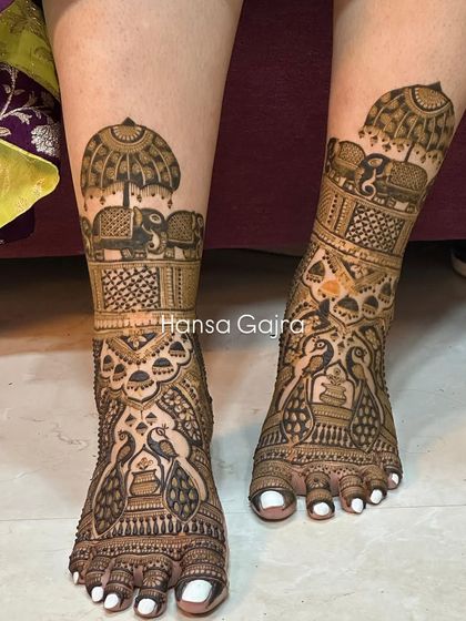 A grand leg design featuring peacocks in a jharokha (window) and royal elephants under an umbrella. This is for the bride who wants her mehendi to be a true work of art.