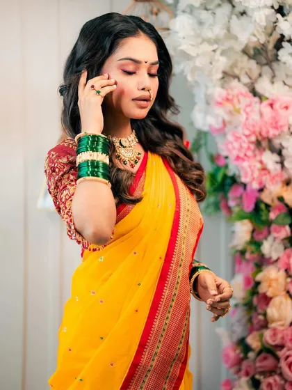 A model showcasing a beautiful Haldi or pre-wedding look in a yellow saree, with soft curls and glowing makeup.