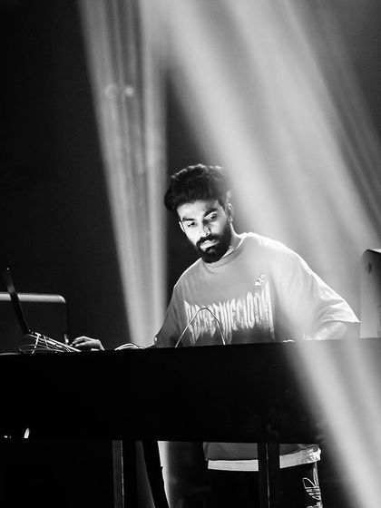 A black and white shot of me in deep concentration at the decks, with spotlights creating a dramatic effect.
