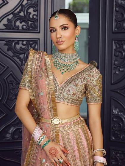 The full bridal look against a modern backdrop. This shows how a pastel lehenga paired with soft, dewy makeup can be just as impactful as a traditional red one.