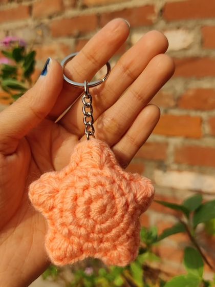 Puffy star-shaped keychains, available in pastel colors like lavender and peach, with an optional pearl strap.