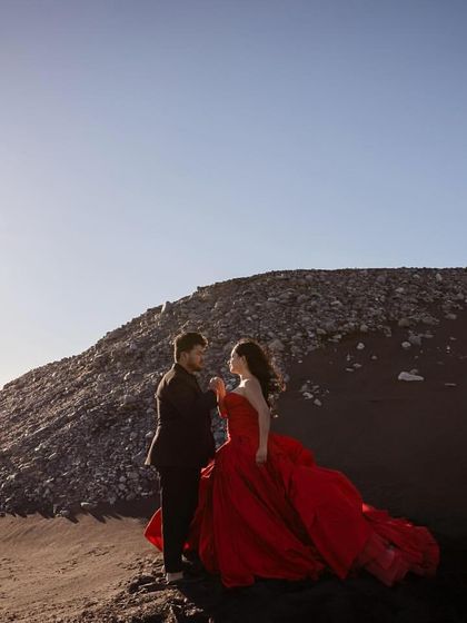 The full picture of romance and style. This shot shows how the couple's outfits work together to create a cohesive and breathtaking scene, blending high fashion with natural beauty.