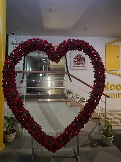 A large heart-shaped arch made of red roses, perfect as a romantic photo booth or entrance decor for a wedding, engagement, or Valentine's event.