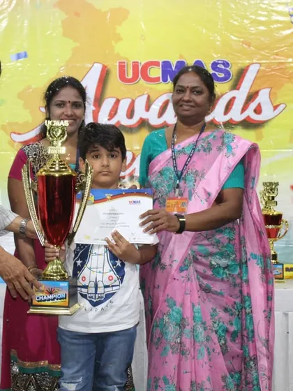 A champion receives his trophy at the NLC Awards Ceremony, surrounded by his proud family and our UCMAS team. It's a celebration for the entire community.