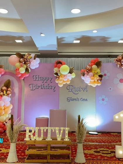 A beautiful Boho-themed first birthday party. This large stage setup uses a soft color palette, pampas grass, and multiple backdrops for a trendy look.