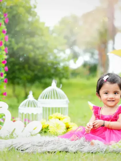Capturing the magic of childhood outdoors, this little girl celebrates her first birthday in a beautiful garden setting. The natural light and whimsical props like the crescent moon and birdcages create a dreamy, fairytale atmosphere.
