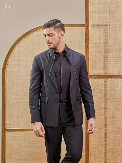 Here is another take on an extraordinary all-black suit. The unique lapel design that extends over the shoulder creates a sartorial elegance that is both modern and memorable.