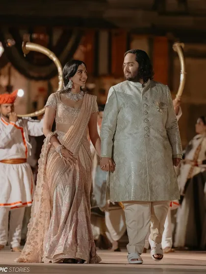 Radhika and Anant walking hand-in-hand during their pre-wedding festivities in Jamnagar. This photo captures their partnership and the joy they shared while being surrounded by traditional fanfare.