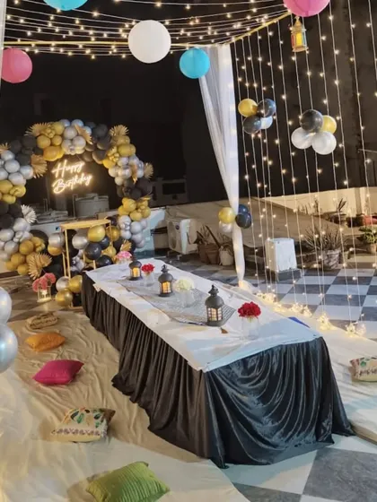 The full view of the terrace canopy setup, showing the fairy light ceiling, drapes, and the balloon photo booth in the background.